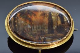 Victorian pinchbeck brooch set with a painted mother of pearl plaque depicting a landscape, 5 x 4cm