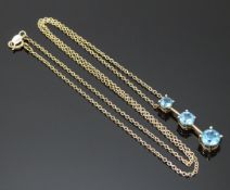 A 9ct gold necklace set with three blue topaz, 2.4g