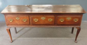 Georgian oak three drawer sideboard with brass drop handles and lock escutcheons, raised on cabriole