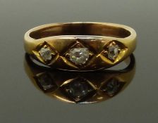 A late Victorian yellow metal ring set with three old cut diamonds, size K, 3.20g