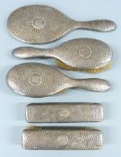 George V hammered hallmarked silver dressing table set comprising mirror and four brushes, London
