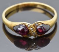 An early Victorian yellow metal ring set with two foiled pear cut garnet cabochons and old cut