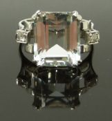 A 14ct white gold ring set with an emerald cut aquamarine and two diamonds, size M, 4.58g