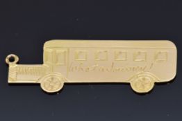A 9ct gold charm in the form of a bus related to the film 'The Journey' reading 