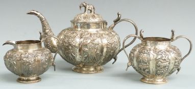 Indian or Burmese white metal three piece teaset with lobed embossed decoration, snake handles and