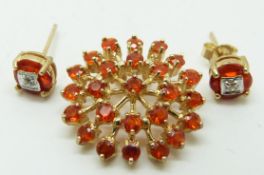 A 9ct gold pendant set with round cut Mexican fire opals and a pair of 9ct gold earrings set with