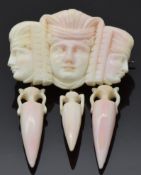 A 19thC Greco Roman carved coral brooch depicting portraits and amphora, 4.6 x 6cm