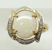 A 9ct gold ring set with a large oval opal cabochon and diamonds, 3.3g, size N