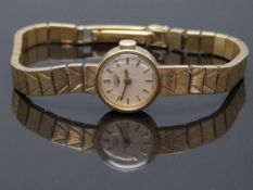 Longines 9ct gold ladies wristwatch with gold hands and baton markers, cream dial and signed 17