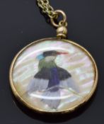 Victorian yellow metal double sided pendant set with a peacock made from feathers on a mother of