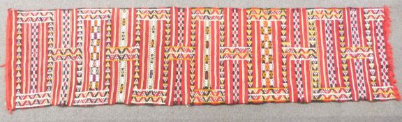 Runner with deep red ground and geometric pattern, 290 x 75cm