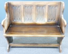 19th/20thC oak settle with carved linen fold decoration and shaped arms, W108cm.