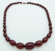 A graduated cherry amber necklace made up of 39 beads, largest bead 21mm x 30mm, 56g