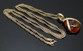 A 9ct gold pendant set with pressed amber on a 9ct gold chain, 6.2g