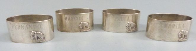 Set of four Indian or similar white metal napkin rings with applied elephants, each marked