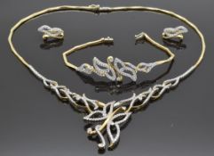 A 14ct gold bi-coloured suite of jewellery comprising bracelet, necklace and earrings set with cubic