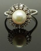 An 18ct white gold ring set with a pearl surrounded by diamonds, size R, 4.89g