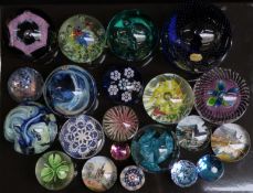Twenty-one various glass paperweights including Caithness, Isle of Wight iridescent and footed