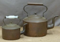 An oversize or large copper kettle together with a further example with glass handle, both with