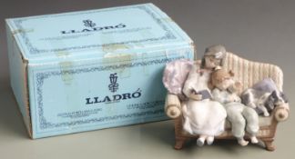 Lladro figure of a girl reading to a small child with spaniel on a sofa, with box, H 16.5cm