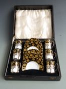 A cased Aynsley coffee set with enamelled decoration the cups in hallmarked silver holders