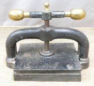 Cast iron book press with brass handles, width 42cm