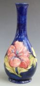Moorcroft pedestal bottle vase in Hibiscus pattern on a blue ground, H 27cm