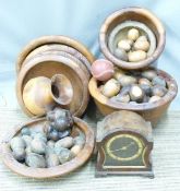A collection of turned wooden bowls, eggs, carving and a mantel clock.