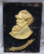 A 19thC gilt metal plaque depicting Charles Dickens with name below, mounted on velvet covered