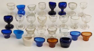 Twenty-eight glass, ceramic and other 19thC and later eye baths including Bristol blue.