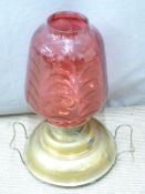 A 19thC brass oil lamp with wide 'ship's style' base and cranberry glass shade, height 52cm