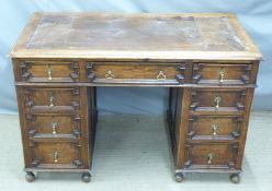 An early 20thC oak tooled leather inset twin pedestal desk with graduated drawers, W122 x D67 x H80