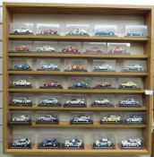 Seventy diecast model rally cars, all in original display boxes and in two glazed wooden display