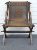 Victorian carved oak Glastonbury chair with Latin motto, W70 x D52 x H87