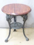 A cast iron pub type table with mask decoration, diameter 60 x H71cm
