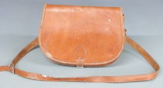 A brown leather shotgun cartridge bag with various compartments and shoulder strap.