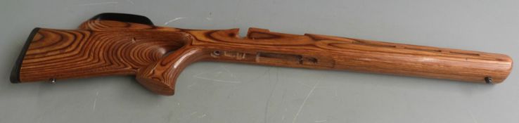 Two laminate show wood bolt-action rifle stocks with shaped semi-pistol grips and raised cheek