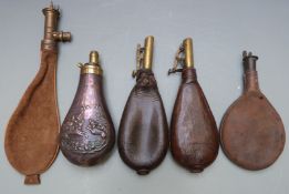 Five shot and powder flasks comprising one copper and brass with embossed decoration of dogs