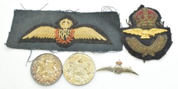 A 9ct white gold RAF brooch set with diamonds and enamel (5.4g), two silver and two cloth RAF badges