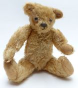 Vintage straw-filled Teddy bear with blonde mohair, glass eyes and jointed limbs, 29cm tall.
