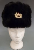 Two Russian fur hats with military/ political badge to front and quilted lining