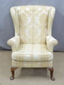 An upholstered wing back armchair, H97cm