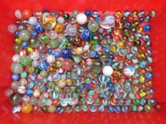 A collection of glass marbles including a large multi-coloured latticino example, largest 38mm in