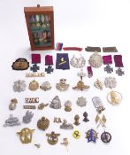 Collection of metal and cloth badges, mainly British Army including Highland Light Infantry,