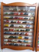 One-hundred-and-twenty Matchbox, Lledo and similar diecast model vehicles, in two glazed wooden