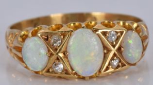 An 18ct gold ring set with three opals and diamonds, 2.9g, size M