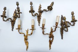 Five gilt metal Rococo style wall lights/ brackets comprising a pair and a set of three, height of