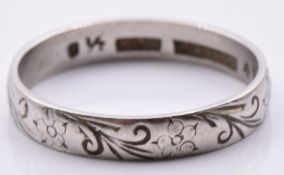 A platinum ring set with chased decoration, 3.5g, size O