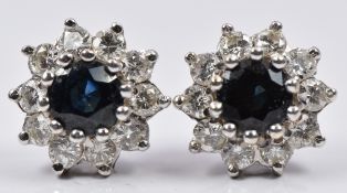 A pair of 18ct white gold earrings each set with a sapphire surrounded by diamonds, diameter 0.5cm