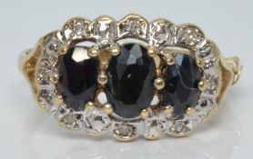 A 9ct gold ring with three oval cut sapphires surrounded by diamonds, 2.4g, size M